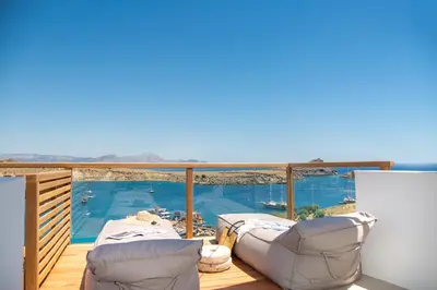 a balcony with a view of a swimming pool at Lindian Ethos in Líndos