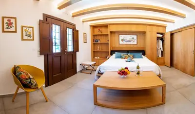 a bedroom with a bed and a table in a room at IN Lindos in Líndos