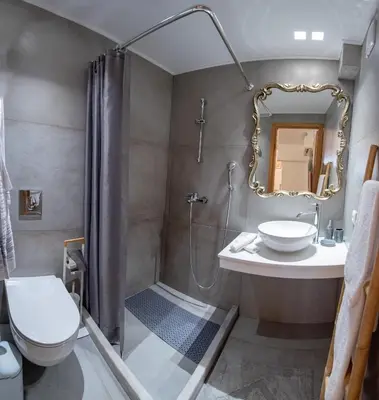 a bathroom with a shower and a toilet and a sink at IN Lindos in Líndos