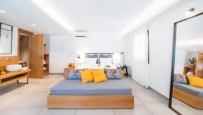 a bedroom with a large bed with yellow pillows at IN Lindos in Líndos