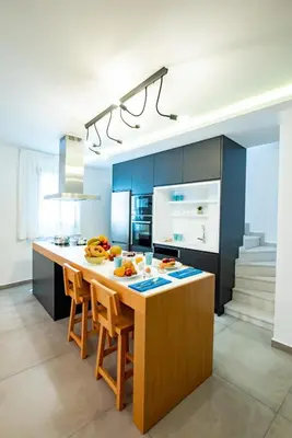 a kitchen with a large island in a kitchen with blue cabinets at IN Lindos in Líndos