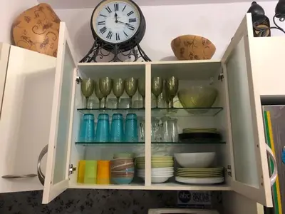 a cabinet with plates and a clock on top of it at Luxury Villa Ioannis in Líndos