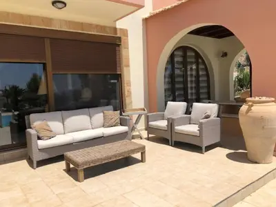 a patio with two couches and a table and a vase at Luxury Villa Ioannis in Líndos