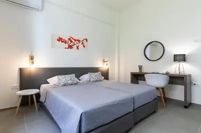 a bedroom with a bed and a desk and a mirror at Rose Central Master Bedroom Apartment in Rhodes Town