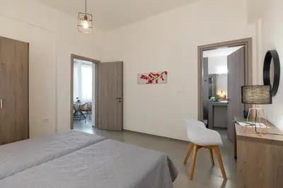 a bedroom with a bed and a desk and a chair at Rose Central Master Bedroom Apartment in Rhodes Town