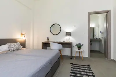 a bedroom with a bed and a desk and a mirror at Rose Central Master Bedroom Apartment in Rhodes Town