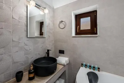 a bathroom with a sink and a bath tub at BIBLIOTHEQUE in Rhodes Town