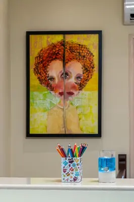 a painting of a woman on a wall with pens at BIBLIOTHEQUE in Rhodes Town