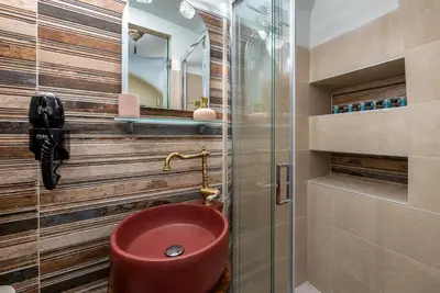a bathroom with a red toilet and a mirror at BIBLIOTHEQUE in Rhodes Town