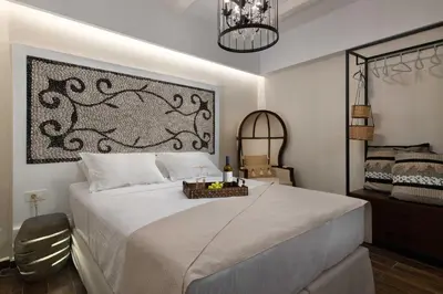 a bedroom with a large white bed and a chandelier at Casa Pietra Lindos Luxury Traditional House in Líndos
