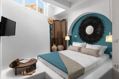 a bedroom with a bed and a mirror and a table at Casa Pietra Lindos Luxury Traditional House in Líndos