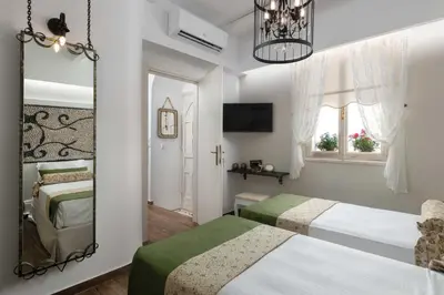 a bedroom with two beds and a mirror at Casa Pietra Lindos Luxury Traditional House in Líndos