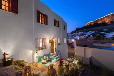 a white house with a staircase leading to a porch at Casa Pietra Lindos Luxury Traditional House in Líndos