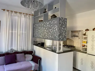 a living room with a couch and a kitchen at the bougainvillea house in Symi