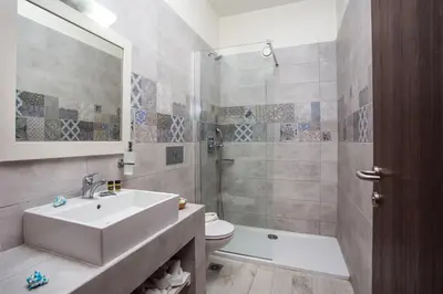 a bathroom with a sink and a toilet and a shower at Evita in Faliraki