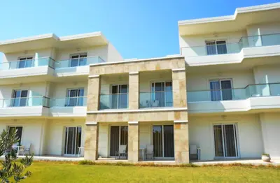 an apartment building with balconies and a lawn at Evita in Faliraki