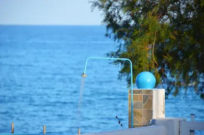 a blue balloon sitting on a wall next to the water at George's Studios in Archangelos
