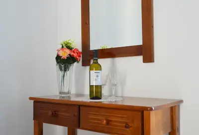 a bottle of wine and a vase of flowers on a table at George's Studios in Archangelos