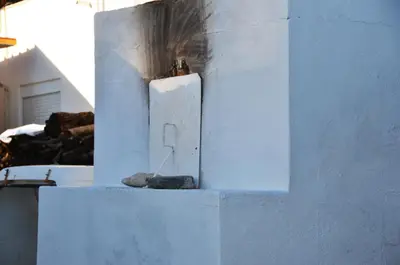 a white wall with a candle on top of it at George's Studios in Archangelos