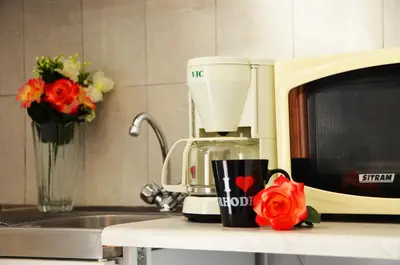 a coffee mug sitting on a counter next to a microwave at George's Studios in Archangelos