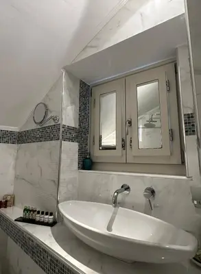 a white bathroom with a sink and a mirror at Thea in Symi