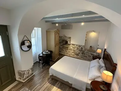 a bedroom with a white bed and a table at Thea in Symi