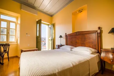 a bedroom with a large bed with yellow walls at Thea in Symi