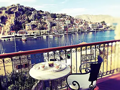 a table with two cups of coffee on a balcony at Thea in Symi