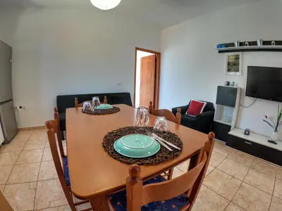 a dining room with a table and a couch at Irene Double Apartment Anoi in Symi