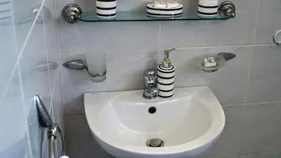 a bathroom with a white sink in a room at Irene Double Apartment Anoi in Symi