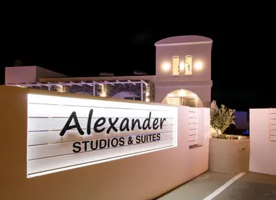 a sign for aksender studios and suites at night at Alexander Studios & Suites - Adults Only in Faliraki