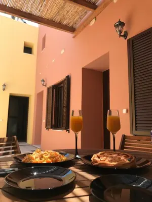 two pizzas on a table with two glasses of orange juice at Apartments in the center marasia in Rhodes Town