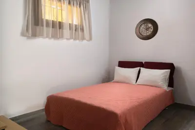 a bed in a room with a clock on the wall at Apartments in the center marasia in Rhodes Town