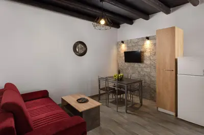 a living room with a red couch and a table at Apartments in the center marasia in Rhodes Town