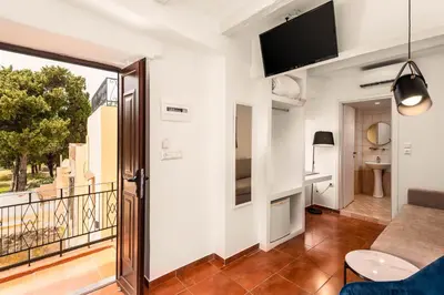 a living room with a tv and a balcony at Casa De La Sera in Rhodes Town