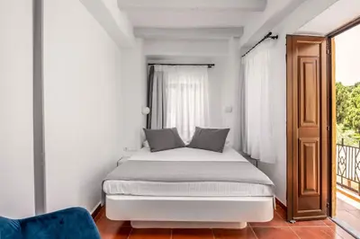 a white bedroom with a bed and a window at Casa De La Sera in Rhodes Town