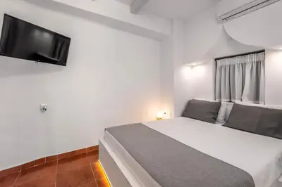 a bedroom with a bed and a flat screen tv at Casa De La Sera in Rhodes Town