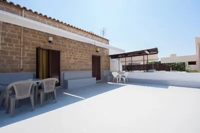 a patio with chairs and tables on a building at Stavros Pension in Rhodes Town
