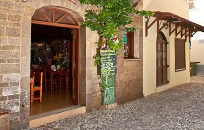 a store with a sign on the side of a building at Stavros Pension in Rhodes Town