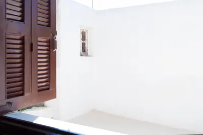 an open wooden door on a white wall at Stavros Pension in Rhodes Town