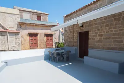 a patio with chairs and a table on a building at Stavros Pension in Rhodes Town
