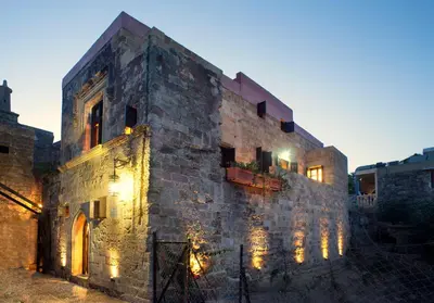 an old stone building with lights on it at Mystic Hotel - Adults only in Rhodes Town