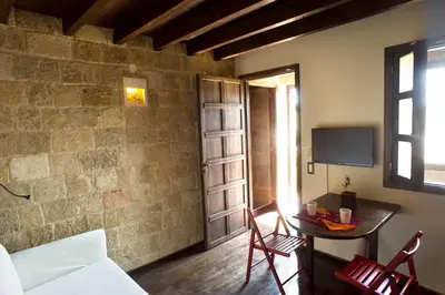 a living room with a table and a tv in a room at Mystic Hotel - Adults only in Rhodes Town