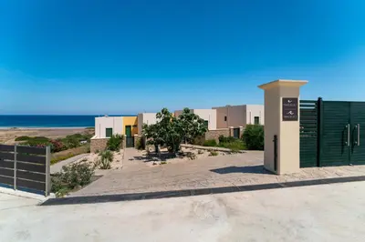 a building with a fence and the ocean in the background at Mare Blu 1 on the beach in Gennadi