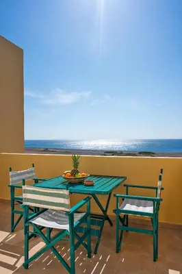 a table and chairs with a view of the ocean at Mare Blu 1 on the beach in Gennadi