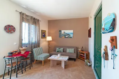 a living room with a couch and a table at Mare Blu 1 on the beach in Gennadi