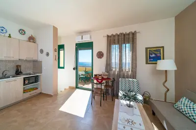 a kitchen and living room with a table and chairs at Mare Blu 1 on the beach in Gennadi