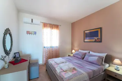a bedroom with a bed and a window at Mare Blu 1 on the beach in Gennadi