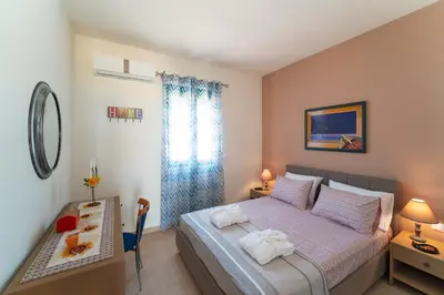a bedroom with a bed and a desk and a table at Mare Blu 2 on the beach in Gennadi