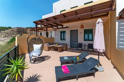a patio with a table and chairs on a balcony at Mare Blu 2 on the beach in Gennadi